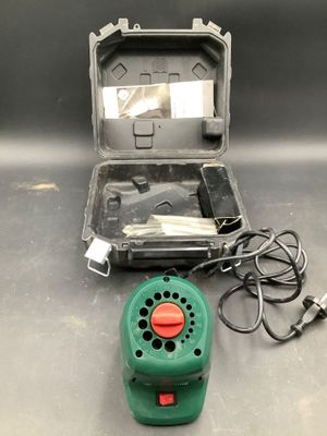 a green blow dryer sitting on a table next to a case