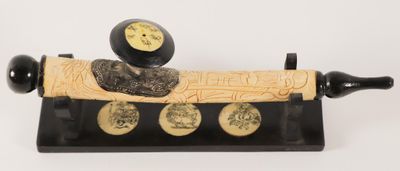 a black and gold object on a stand with coins