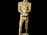 a gold statue of a man with a sword on a black background