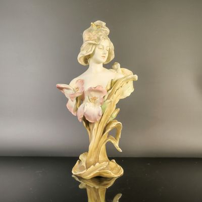 an antique figurine of a woman with flowers in her hair