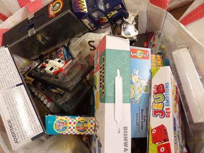 beaucoup de jouets dans un sac en plastique posé par terre