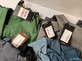 a pile of clothes with tags on them on a shelf