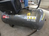 a black air compressor sitting on the ground in a garage