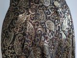 a close up of a mannequin wearing a black and gold patterned skirt