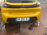 the rear end of a yellow car parked on the side of the road