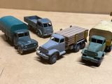 Plusieurs camions miniatures sont alignés en rang sur une table