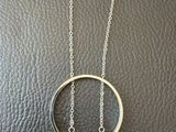 un collier en écaille de tortue et argent posé sur un fond en cuir noir