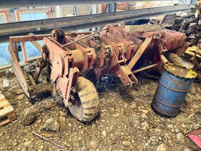un tracteur posé au sol à côté d'un tonneau