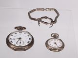 deux montres et un bracelet exposés dans une vitrine