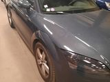 a blue car parked in a garage with other cars in the background