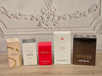 quatre boîtes de parfum posées les unes à côté des autres sur une table