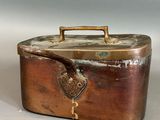 a small metal box with a handle on a table