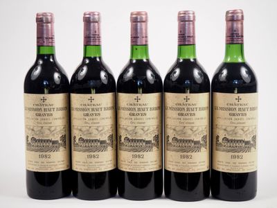 six bouteilles de vin sont alignées sur une surface blanche