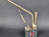 a silver lighter with a rose on it on a table