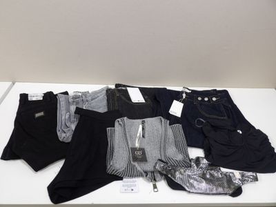 plusieurs paires de pantalons pour homme posées sur une table blanche