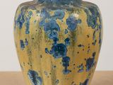 a blue and yellow vase sitting on a table