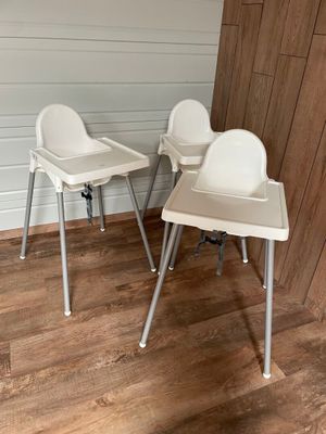 une paire de chaises hautes blanches dans une pièce avec un parquet