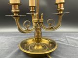 three candles that are on a brass plate on a table