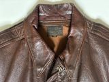 brown leather jacket with a label on the back of it