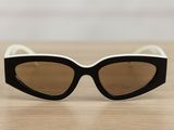 black and white cat eye sunglasses sitting on a wooden table