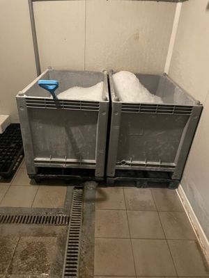 two bins that have snow in them on the floor