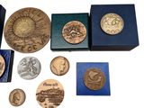 some of the coins are in a blue box and some are on a white surface