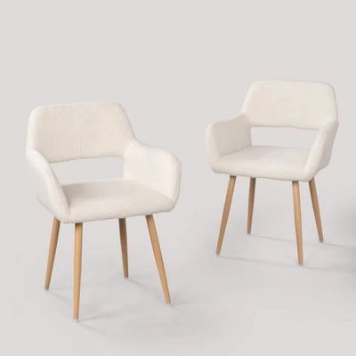 deux chaises aux pieds en bois et une chaise rembourrée blanche devant un mur blanc