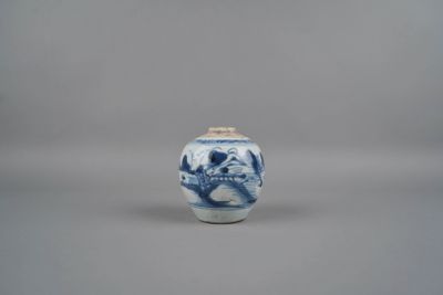 un petit vase bleu et blanc orné d'un singe