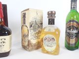 plusieurs bouteilles d'alcool sont alignées sur une surface blanche