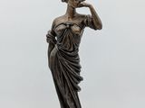 a bronze statue of a woman holding a lamp on a white background