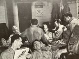 many men sitting in a room together reading newspapers