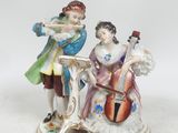une figurine représentant un homme et une femme jouant d'un instrument de musique