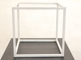 a white box with a black base on a table