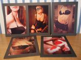 three framed photos of women in lingersuits on a wooden table