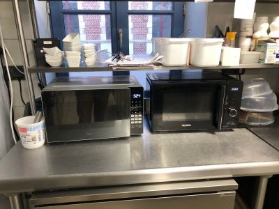 two microwaves sitting on a counter in a kitchen