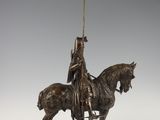 bronze statue of a man on a horse with a spear