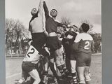 black and white photograph of a group of men playing a game of rugby