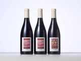 three bottles of wine sitting on top of a table next to each other