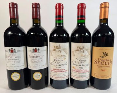 four bottles of red wine are lined up on a white surface