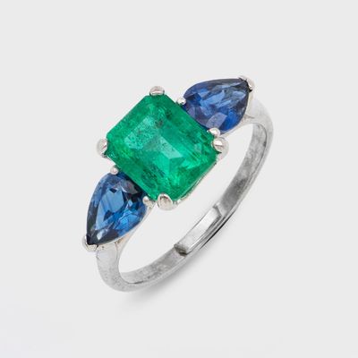 une bague sertie d'une émeraude et d'un saphir bleu sur fond blanc