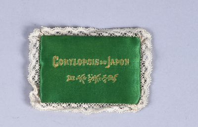 a green and white embroidered badge with gold writing on it