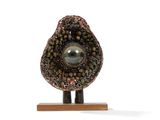 an image of a stone sculpture on a wooden stand
