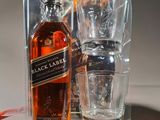 a bottle of black label next to a shot glass on a table
