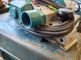a blue suitcase with a hose on top of it