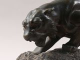 statue of a black panther on a rock with a white background