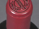 a close up of a wine bottle with a red cap
