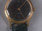 une montre-bracelet en or avec un cadran noir et un bracelet noir