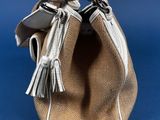 a close up of a purse on a blue background with a cell phone in it