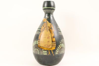un vase noir et jaune orné d'une image représentant une femme