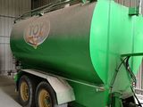 un gros camion-citerne vert garé à l'intérieur d'un bâtiment